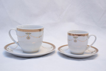 Mock up / design set of elegant and traditional teapot colorful white blue gold coffee cup & Tea cup on cup's plate beside the hot tea pot , design/ drink-ware isolated on white background