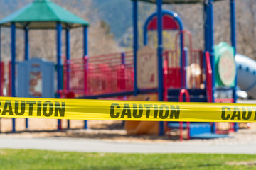 Close-up of cordon tape blocking off a children's playground during coronavirus pandemic