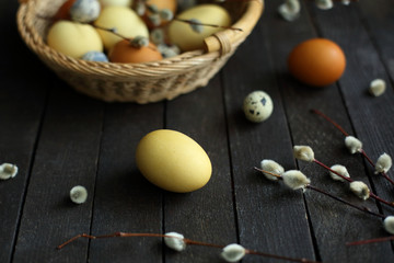 Fototapeta na wymiar yellow and brown Easter eggs in a basket on a wooden background