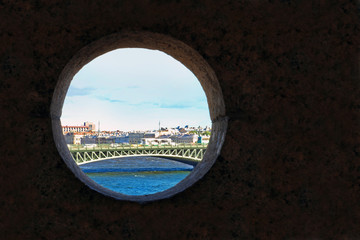 Obraz na płótnie Canvas View of Saint Petersburg through a hole in the wall of the Peter and Paul Bastion