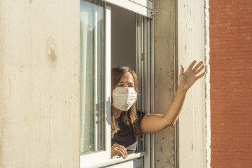 Fototapeta na wymiar Woman in the windows during quarantine greeting a neighbor