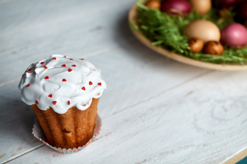 Easter cake and eggs on a light wooden background