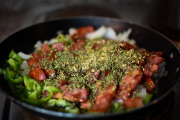 Frying pan with vegetables and condiments