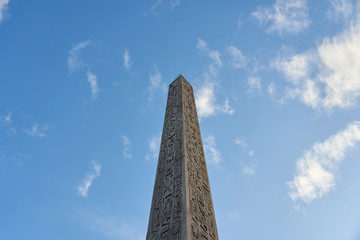 The Luxor Obelisk or Egyptian obelisk on the Place de la Concorde against a blue sky in Paris,...