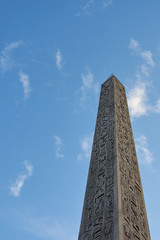 The Luxor Obelisk or Egyptian obelisk on the Place de la Concorde against a blue sky in Paris,...