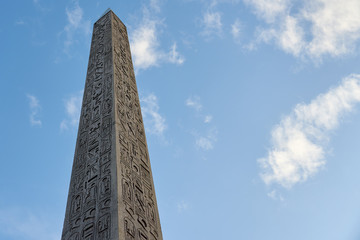 The Luxor Obelisk or Egyptian obelisk on the Place de la Concorde against a blue sky in Paris,...