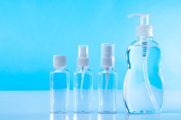 Bottles of disinfectants on a blue background. The maintenance of hygiene. The concept of cleanliness. Elimination of viruses and bacteria. Treatment of hands and surfaces during the quarantine period