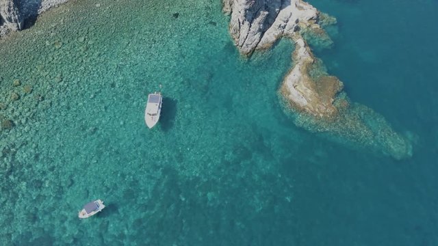 The sea of ​​Pantelleria with its jagged and volcanic coast. Turquoise colored sea. Dammusi, typical houses of Pantelleria.