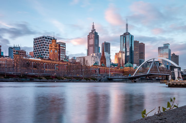 Obraz premium Melbourne, Victoria / Australia - Jun 25 2014: The view to the Flinders Street Station from the Southbank Promenade beside the Yarra River in Melbourne, Victoria, Australia.