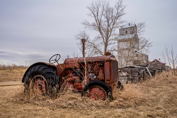 A vintage tractor with the Coderre, Saskatchewan elevator in the background
