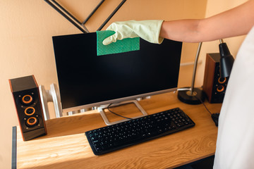 Beautiful caucasian woman cleans dust on furniture in room