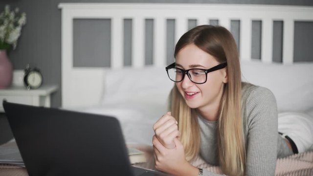 Close up of female freelancer lying on the bed and watch a fanny video in her timeout