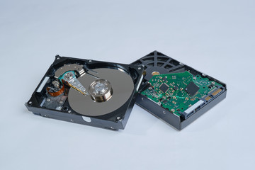 Two defective computer hard drives, head and board