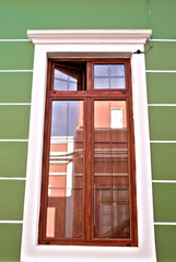 Tall wooden window frame in a green wall.