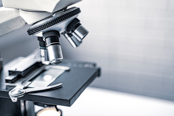 close up microscope stage and objectives researching corona virus microscopic cells behavior testing vaccination cure, in medical center lab china Wuhan world health organization research facilities