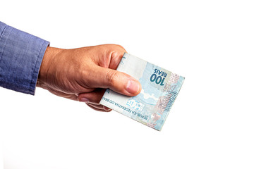 hand holding several banknotes of one hundred reais from Brazil, on isolated white background. Emergency government aid paid to micro entrepreneurs, worth 600 reais