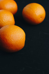 Oranges on black textured background.