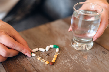 Close up of pills and a glass of water on the table