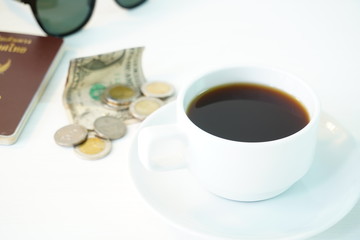 Coffee and money on a white table. The concept of travel.