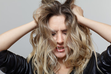 Portrait of young female with black leather jacket, with shaggy hair and closed eyes