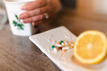Close up of lemon, pills and tea on the table