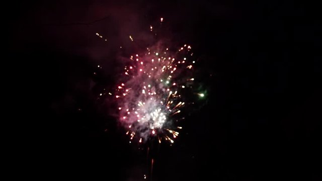 Fireworks display at dark night sky in slow motion handheld blur