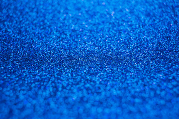 Sparkling bright blue glitter texture background with defocused bokeh