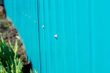 The wall of the building siding bright blue color on the background of the earth