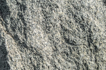 Uneven texture of white stone with black flecks