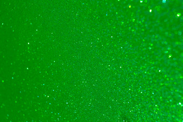 Sparkling lime green glitter texture background with defocused bokeh