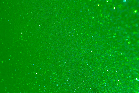 Sparkling lime green glitter texture background with defocused bokeh