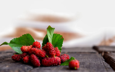 Mulberries with leafs on wood background,, mulberry fruit on wooden table ,selective focus