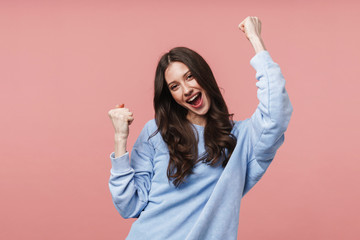 Image of attractive young woman smiling and gesturing in success