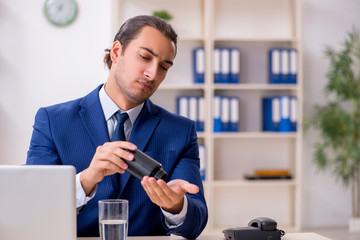 Young male employee and a lot of pills on the desk