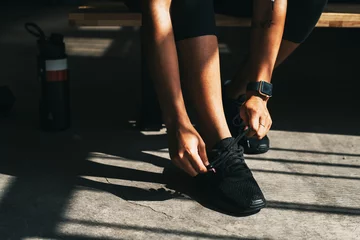 Gordijnen Fit woman tying her shoes © rawpixel.com