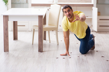 Young man and a lot of cockroaches at home