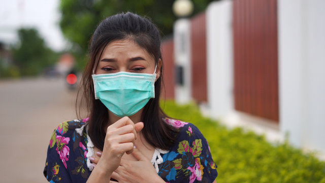 sick woman wearing surgical mask (medical mask) is coughing, virus protection