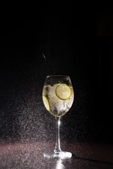 refreshing cocktail on a neutral black background with flying splashes in the air