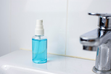 Alcohol sanitizer spray bottle on wash basin in toilet for disinfecting surface in a home,Coronavirus and Covid-19 prevention concept.