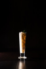 creamy alcohol cocktail with mint leaves on a neutral black background