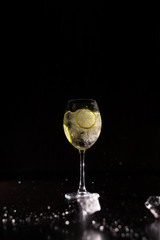 refreshing cocktail on a neutral black background with flying ice cubes in the air crashing on a table