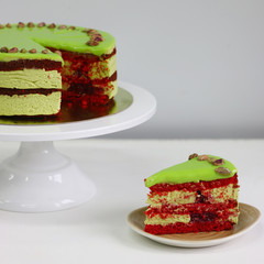 Raspberry cake with pistachio on a light background. red velvet cake. sliced dessert closeup