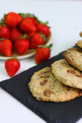 cookie with chocolate on plate and strawberry on light background.