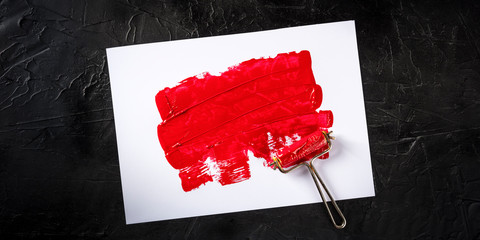 Red paint background panorama with a roller, an abstract texture with copy space