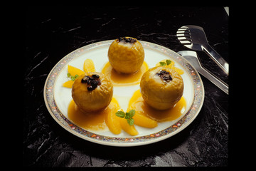 Homemade oven baked apples stuffed in white plate on Slate stone