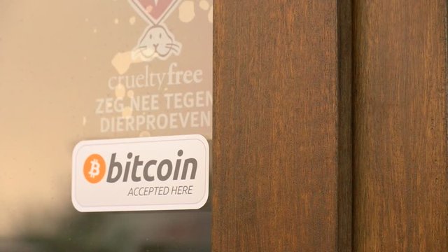Cripto currency Bitcoin sticker label as door opens of bitcoin shop. Close shot.