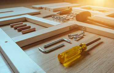 Top view of furniture assembly parts and wood work tools on wooden floor for DIY do it yourself