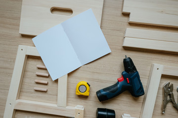 Top view of furniture assembly parts and Screwdriver on wooden floor for DIY do it yourself and...