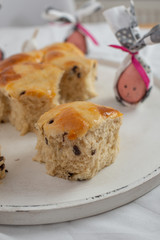 Freshly baked Traditional home made hot cross buns with chocolate chips on a easter table