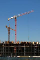 Tower cranes are working on the construction of a new house. Lifting crane.